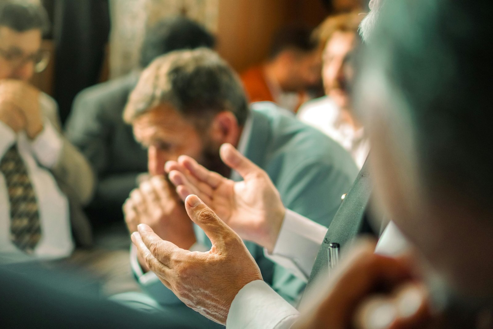 A group of people in a prayer meeting with focused expressions, highlighting spirituality and devotion.